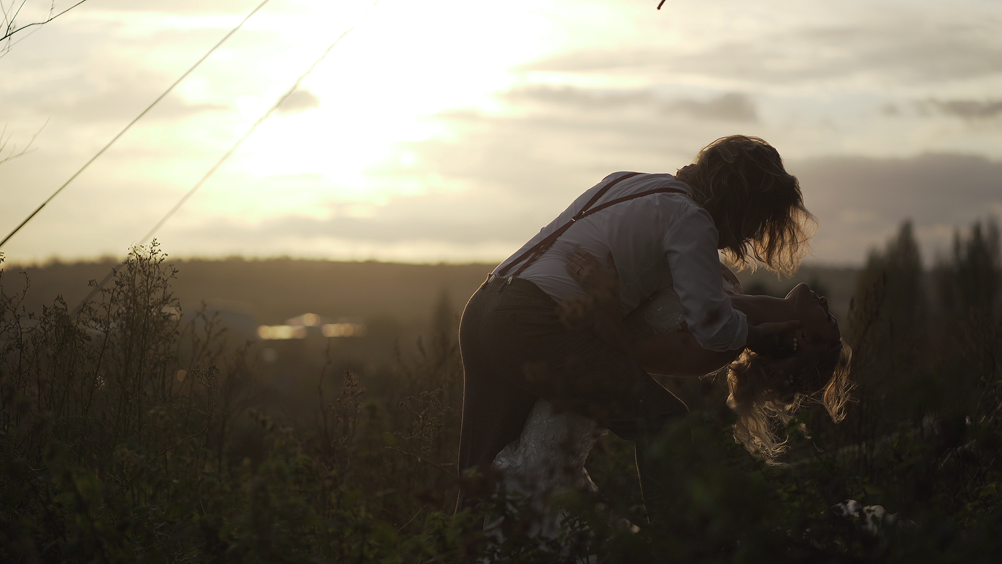 groom dipping bride in front of beautiful sunset