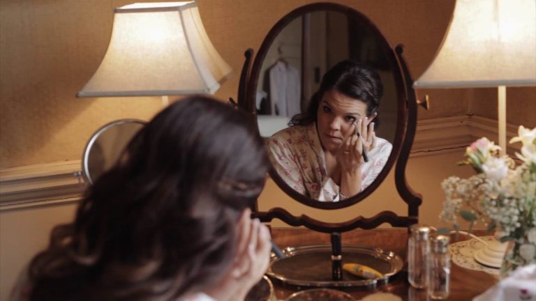 Bride at Catton Hall doing her make up in a vintage mirror