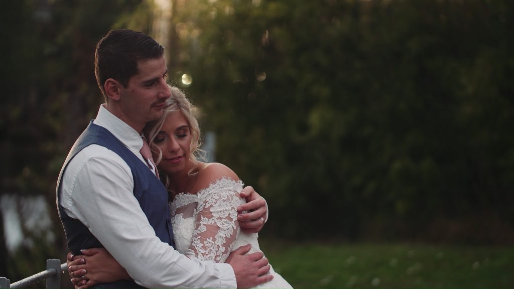 Bride and Groom snuggle by the river at The West Mill