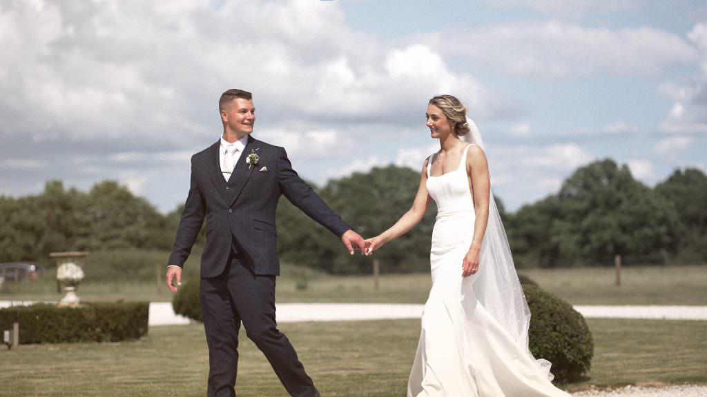 Bride and groom walking together holding hands