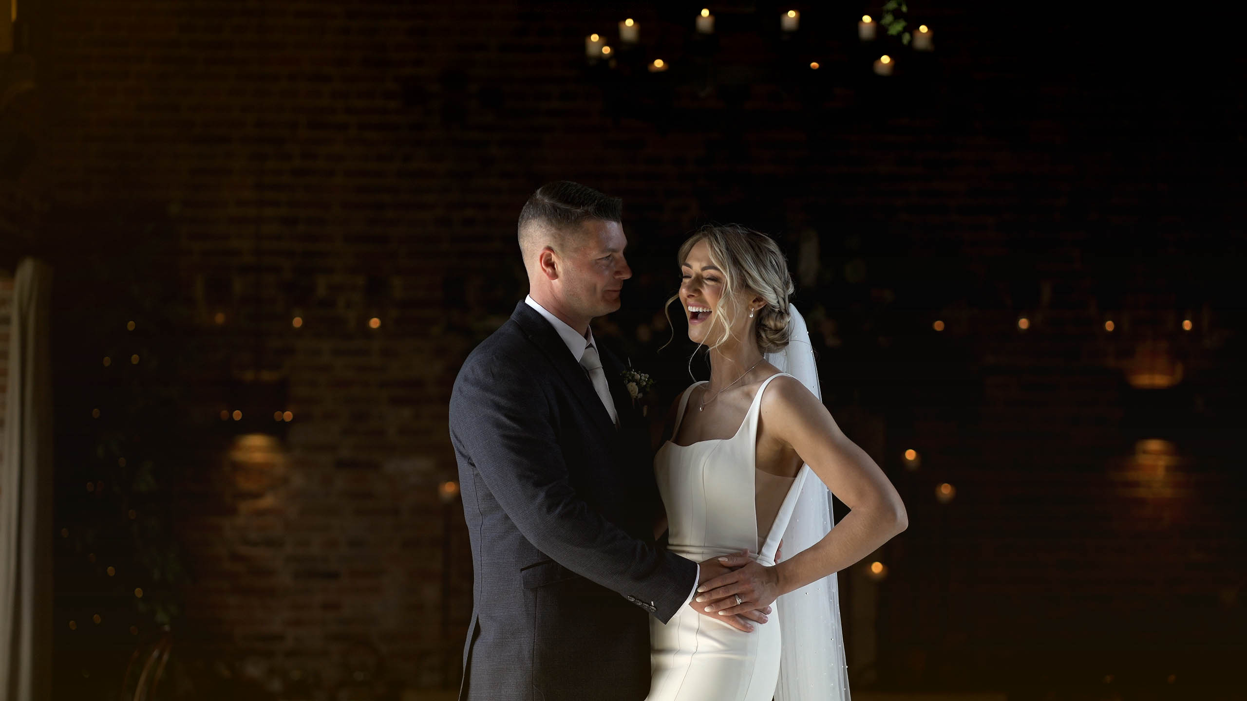 Bride laughing at groom as they pose for a photo together