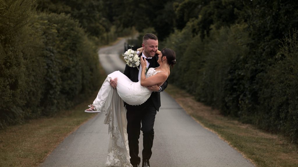 Groom running with his bride in his arms