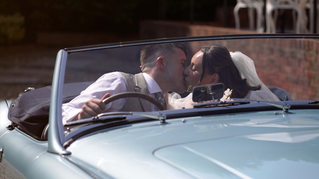 Bride and Groom kissing in vintage car